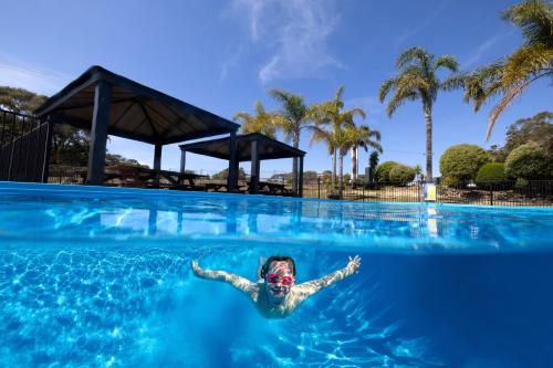 une personne nageant dans l'eau dans une piscine dans l'établissement BIG4 Wallaga Lake Holiday Park, à Bermagui