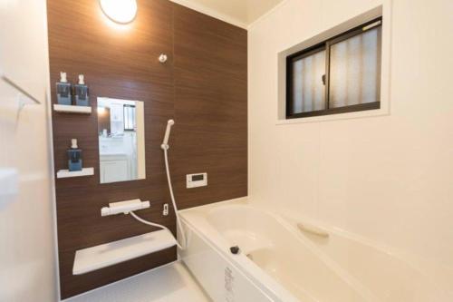 a bathroom with a bath tub and a sink at 駐車場無料！静かな住宅街　４つの寝室でご家族でゆっくりお過ごし頂けます　7台の寝具で最大11名様まで in Osaka