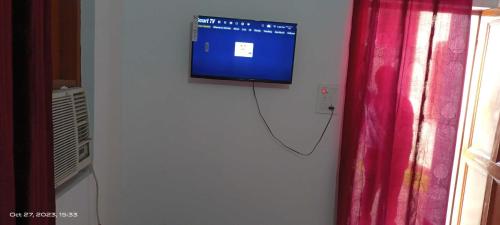 uma televisão de ecrã plano pendurada numa parede ao lado de uma janela em OYO Yug Hotel & Resturant em Moradabad