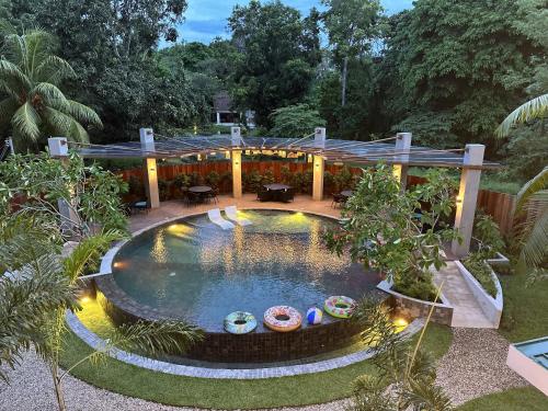 einen Pool in einem Garten mit einem Gebäude in der Unterkunft Hotel Dumaguete in Dumaguete