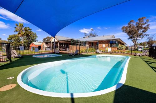 una imagen de una piscina frente a una casa en BIG4 Mudgee Holiday Park en Mudgee