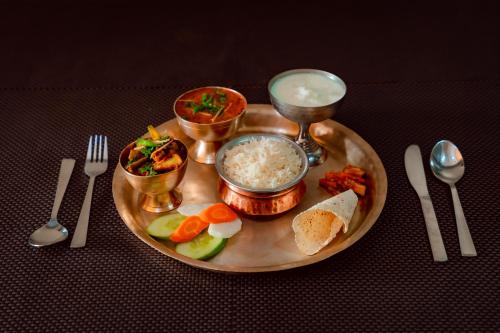 une plaque de nourriture avec du riz et des légumes sur une table dans l'établissement Hotel Everest Inn Pvt. Ltd., à Butwāl