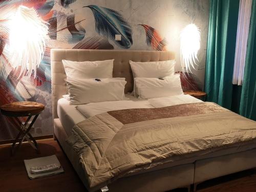 a bedroom with a large bed with white sheets and pillows at Boutique Hotel & Bio Wirtshaus Schwarzer Bock in Ansbach