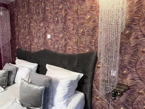 a room with a bed and a wall with a pattern at Boutique Hotel & Bio Wirtshaus Schwarzer Bock in Ansbach