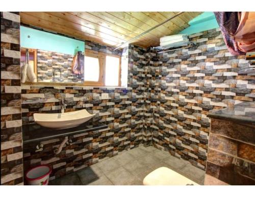 ein Bad mit einem Waschbecken und einem Spiegel in der Unterkunft Hotel Somraj Regency, Tripura in Agartala
