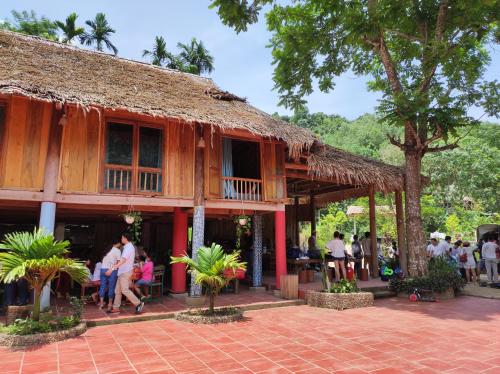 a building with people standing outside of it at LePont Mu Waterfall Bungalow in Hòa Bình