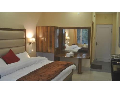 ein Hotelzimmer mit 2 Betten und einem Spiegel in der Unterkunft Hotel Somraj Regency, Tripura in Agartala
