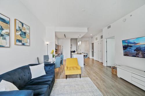 a living room with a blue couch and a yellow chair at Luxury 1 BR with DEN Downtown Tampa Apt - City Views, Rooftop Pool, Workspace in Tampa