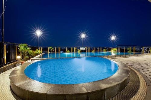 a swimming pool on the roof of a building at night at THE 1O1 Palembang Rajawali in Palembang