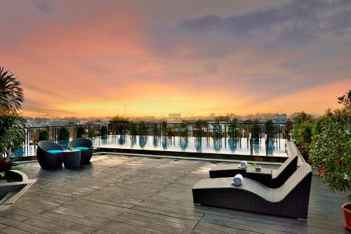 a patio with couches and chairs on top of a building at THE 1O1 Palembang Rajawali in Palembang