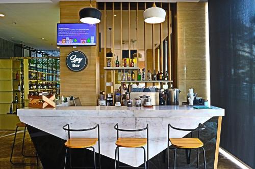 a bar with four stools in front of a counter at THE 1O1 Palembang Rajawali in Palembang