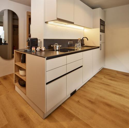a kitchen with white cabinets and a counter at Apart Galeon in Pettneu am Arlberg