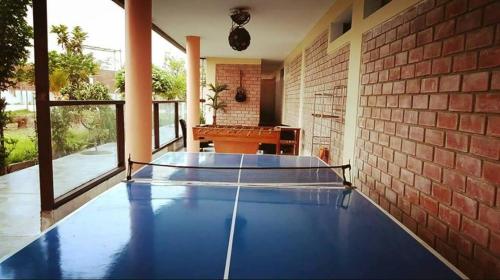 a ping pong table in a room with a brick wall at HOTEL REAL BERNAL in Chincha Alta