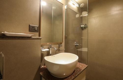 a bathroom with a white sink and a shower at IRA by Orchid, Nashik in Nashik