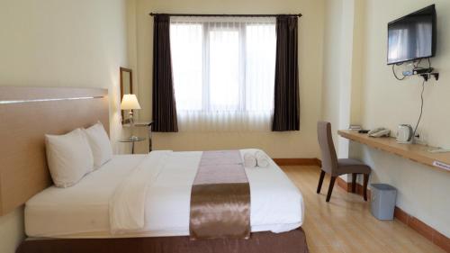 a hotel room with a bed and a window at Revayah Hotels in Ruteng