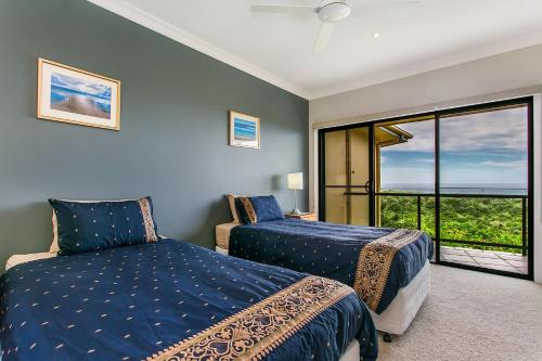 1 dormitorio con 2 camas y balcón en A Perfect Stay - Above Byron en Byron Bay