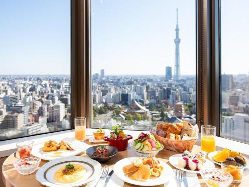 uma mesa com pratos de comida em frente a uma janela em Asakusa View Hotel em Tóquio