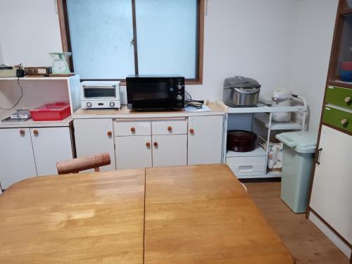 a kitchen with a wooden table in a room at Bayside House Shiosai - Vacation STAY 15343 in Kumano