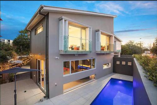 a house with a swimming pool in front of it at Stylish Surfers Paradise Haven 4BR4B Stunning Pool 2 in Gold Coast