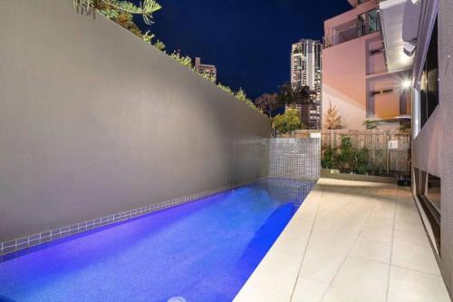 黄金海岸Stylish Surfers Paradise Haven 4BR4B Stunning Pool 2的建筑物中间的游泳池