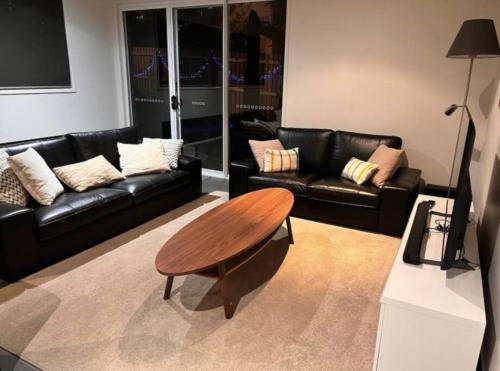 a living room with a couch and a coffee table at Stylish Surfers Paradise Haven 4BR4B Stunning Pool 2 in Gold Coast