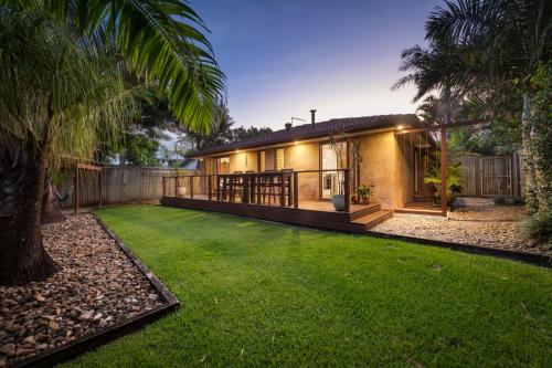 a house with a green lawn in front of it at Tallow Beach Retreat - welcoming pet-friendly unit in Suffolk Park