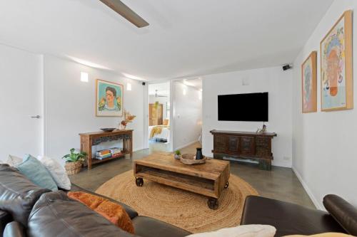 a living room with a couch and a coffee table at Tallow Beach Retreat - welcoming pet-friendly unit in Suffolk Park
