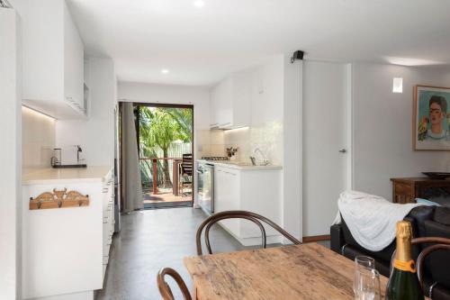 a kitchen and a dining room with a table at Tallow Beach Retreat - welcoming pet-friendly unit in Suffolk Park