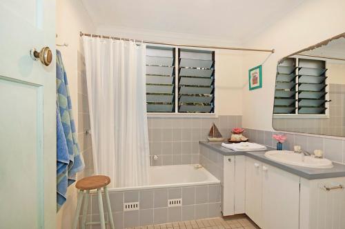a bathroom with a tub and a sink and a bath tub at A Perfect Stay - Aluna in Byron Bay