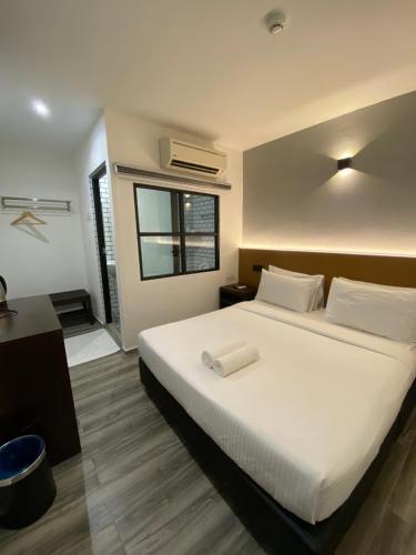 a bedroom with a white bed and a window at Georgetown Inn by Sky Hive in George Town