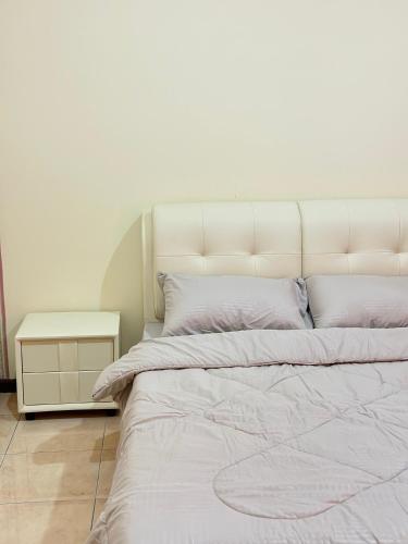 a large white bed with white sheets and pillows at Stutong Stay in Kuching