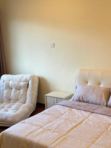 a bedroom with a bed and a couch at Stutong Stay in Kuching