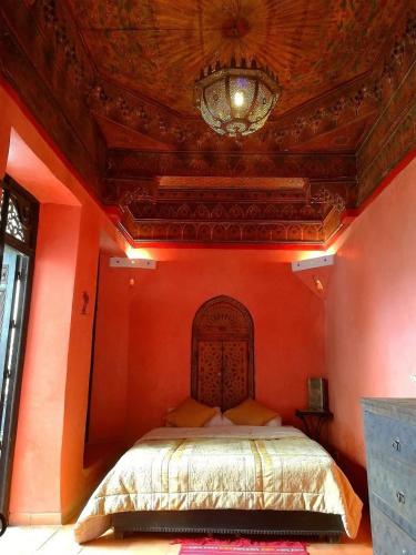 una camera da letto con un letto grande con una parete arancione di Riad Sabbah a Marrakech