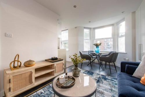 a living room with a blue couch and a table at Elevated Elegance: 1BR 1BA Flat in Wellmeadow Rd in London
