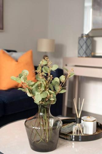 a vase with flowers on a table in a living room at Elevated Elegance: 1BR 1BA Flat in Wellmeadow Rd in London