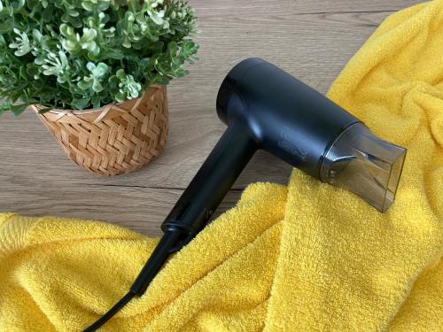 a black hair dryer sitting on a table with a yellow towel at New Pension at ROTOR Brewery in Kunovice