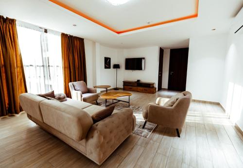 a living room with a couch and two chairs at Veronique Heights in Kumasi
