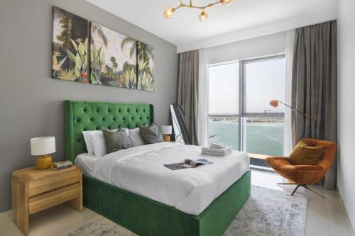 een slaapkamer met een groen bed en een raam bij Sea view 2-Bedroom - Beach Isle in Dubai