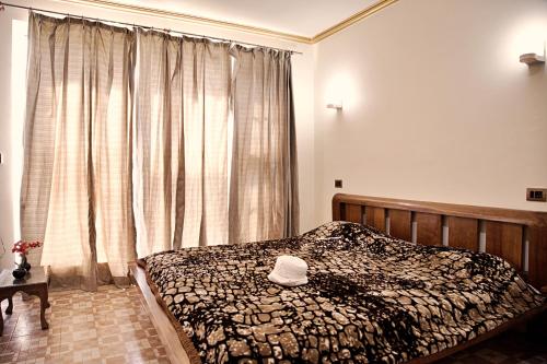 a bedroom with a bed with a hat on it at The GoodFind Residency in Srinagar