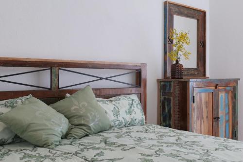 a bedroom with a bed with a wooden headboard and a mirror at Goldener Löwe in Bodman-Ludwigshafen