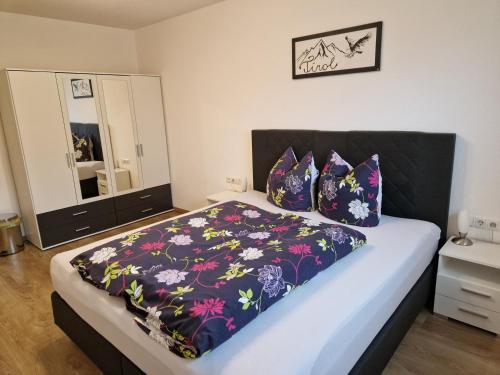 una camera da letto con un letto con copriletto nero e viola di Apart Plattner ad Arzl im Pitztal