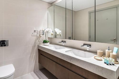 een badkamer met 2 wastafels en een spiegel bij Sea view 2-Bedroom - Beach Isle in Dubai