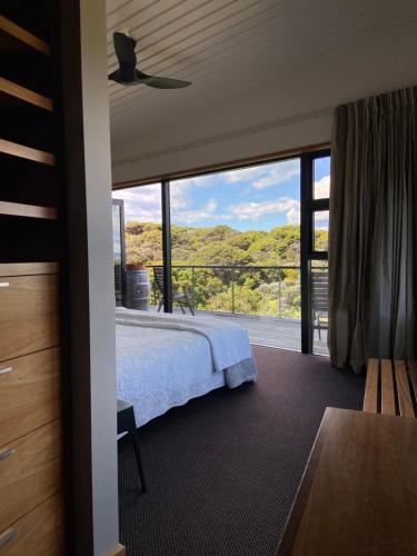 1 dormitorio con cama y ventana grande en La Bodega Waiheke Island, en Surfdale
