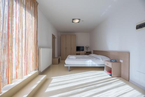 ein Schlafzimmer mit einem Bett und einem großen Fenster in der Unterkunft Andrian Residence in Andrian