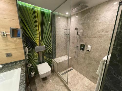 a bathroom with a shower with a toilet and a sink at CLUB GRAND AQUA in Side