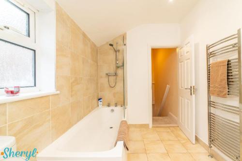 a bathroom with a bath tub and a shower at Scenery Senary by Sheryl - Large house, Right in Town Centre, Near Northampton Gen Hospital in Northampton