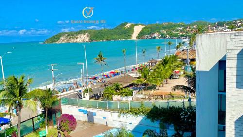 a view of a beach with palm trees and the ocean at Ponta Negra Beach beira-mar in Natal