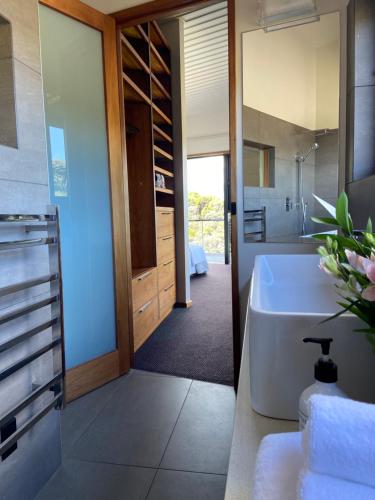 a bathroom with a white tub and a sink at La Bodega Waiheke Island in Surfdale