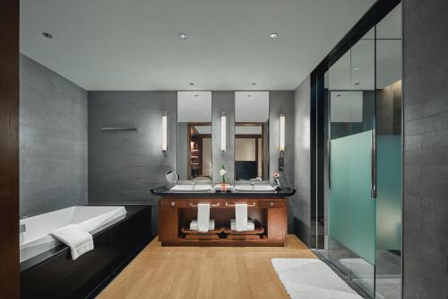 Tonino Lamborghini Hotel Suzhou في سوتشو: حمام مع مغسلتين وحوض استحمام