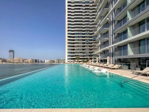 a large swimming pool next to a large building at Sea view 2-Bedroom - Beach Isle in Dubai